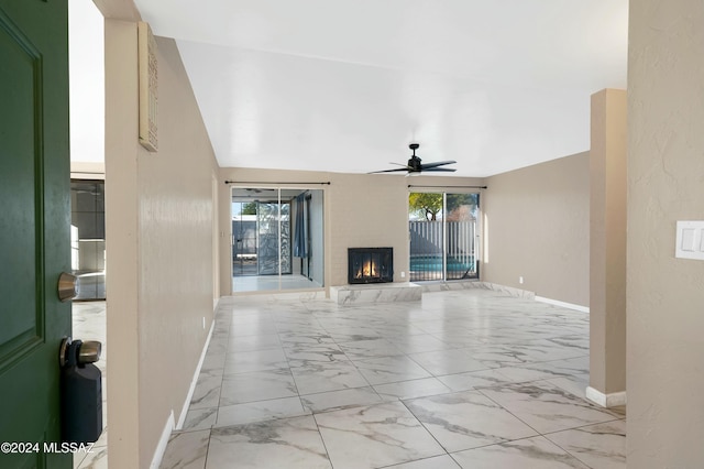 unfurnished living room featuring ceiling fan, a fireplace, and vaulted ceiling