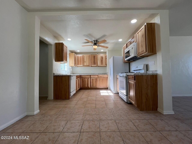 kitchen featuring sink, white appliances, ceiling fan, light stone counters, and light tile patterned flooring