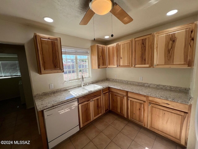 kitchen with sink, light tile patterned floors, dishwasher, ceiling fan, and light stone countertops