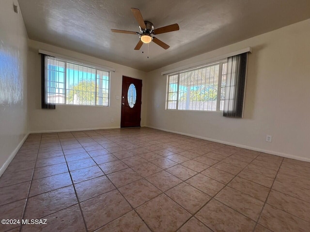 tiled entrance foyer featuring ceiling fan and plenty of natural light