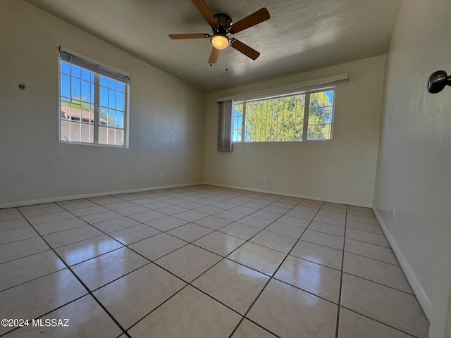 spare room featuring light tile patterned floors and ceiling fan