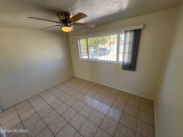 unfurnished room featuring light tile patterned flooring, ceiling fan, and a textured ceiling