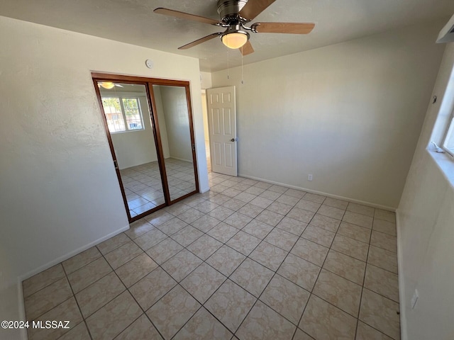 unfurnished bedroom featuring light tile patterned floors, ceiling fan, and a closet