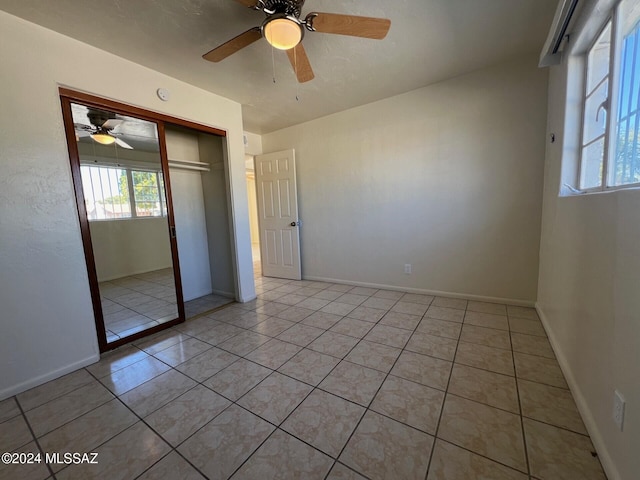 unfurnished bedroom featuring light tile patterned floors, ceiling fan, and a closet