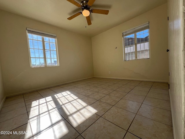 tiled empty room featuring ceiling fan