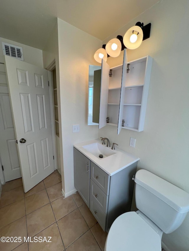 bathroom featuring vanity, tile patterned floors, and toilet