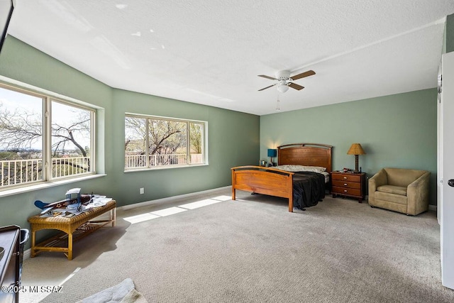 bedroom featuring baseboards, a textured ceiling, a ceiling fan, and carpet floors