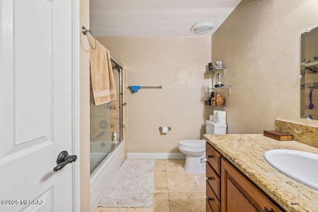 bathroom with shower / bath combination with glass door, vanity, baseboards, tile patterned flooring, and toilet