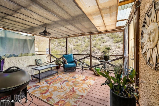 sunroom featuring a ceiling fan and an outdoor hangout area