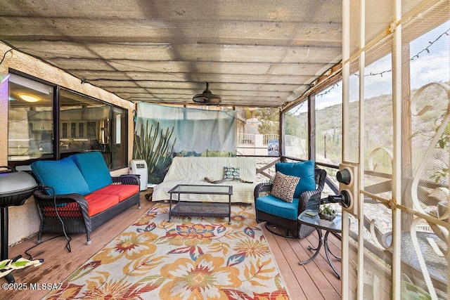 sunroom featuring outdoor lounge area and ceiling fan