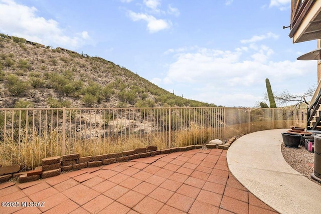 view of patio with a mountain view and fence