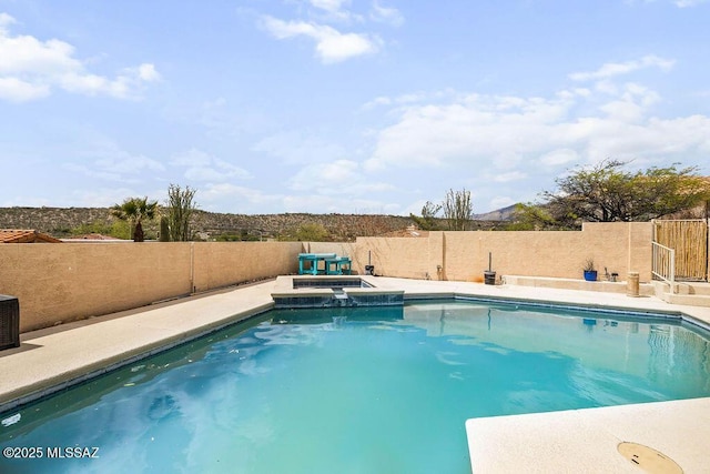 view of pool featuring a fenced backyard and a pool with connected hot tub