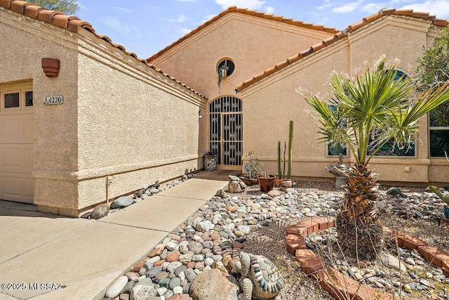 exterior space with a garage and stucco siding