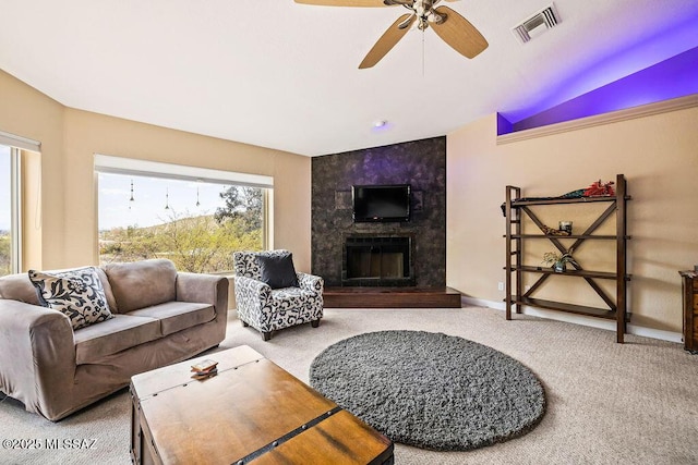 living area with visible vents, baseboards, a ceiling fan, a fireplace, and carpet flooring