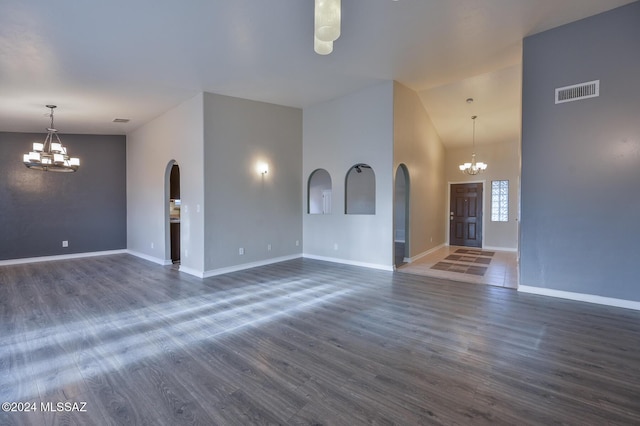 unfurnished living room with dark hardwood / wood-style floors and a notable chandelier