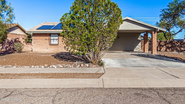 view of front of home with a carport and solar panels