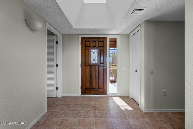 unfurnished living room featuring ceiling fan, french doors, tile patterned floors, a textured ceiling, and a fireplace