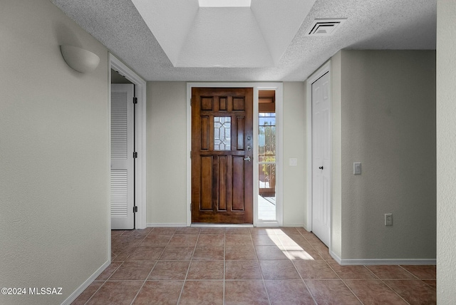 tiled entryway with a textured ceiling