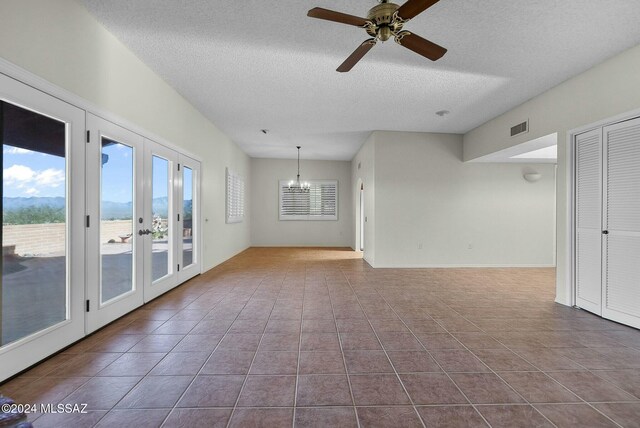 carpeted empty room with a textured ceiling and ceiling fan