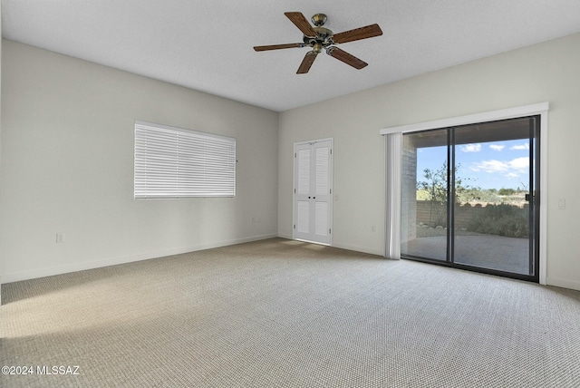 carpeted spare room featuring ceiling fan and a textured ceiling