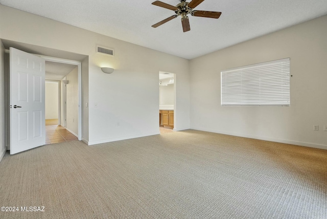 carpeted empty room with ceiling fan and a textured ceiling