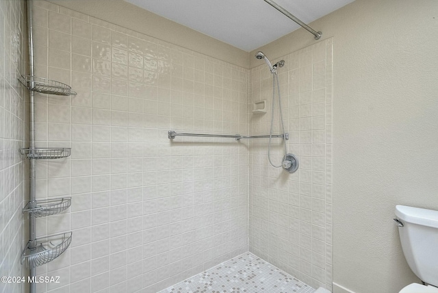 bathroom featuring toilet and tiled shower