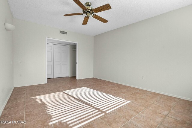 carpeted empty room with a textured ceiling and ceiling fan