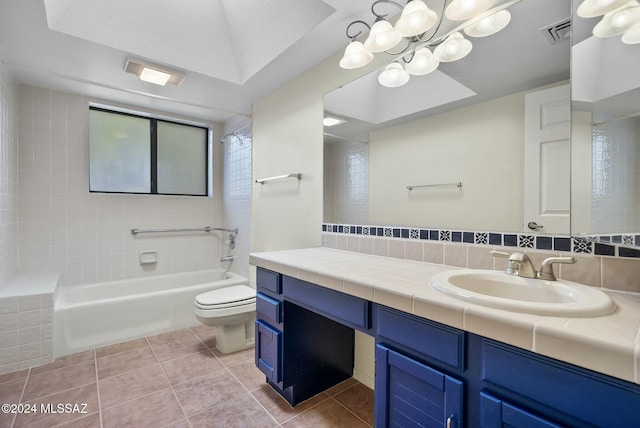 full bathroom with tiled shower / bath combo, tile patterned flooring, a textured ceiling, toilet, and vanity