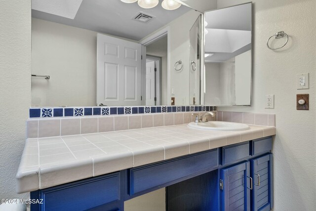 kitchen with kitchen peninsula, a skylight, white appliances, sink, and a notable chandelier