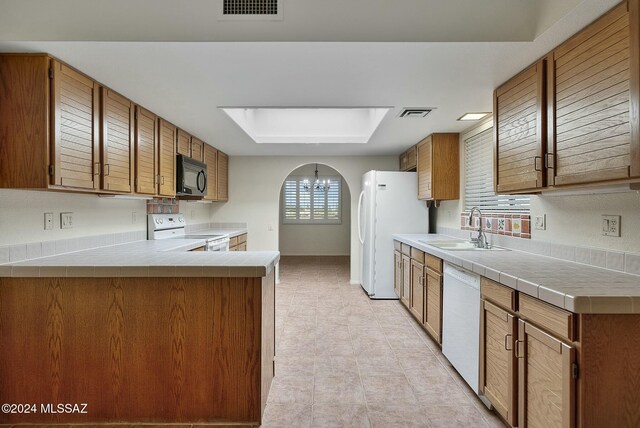 kitchen featuring tile countertops, light tile patterned floors, white dishwasher, and sink