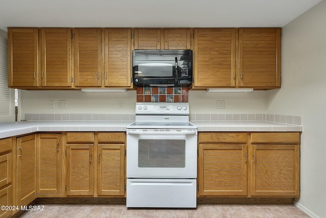 kitchen with tile countertops and white range with electric cooktop