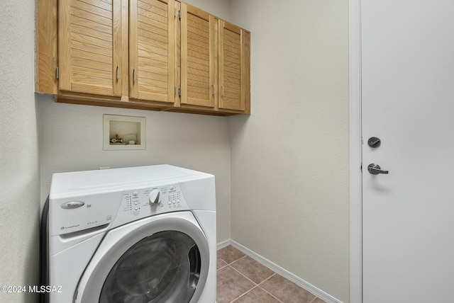 laundry area featuring tile patterned floors, washer / clothes dryer, and cabinets