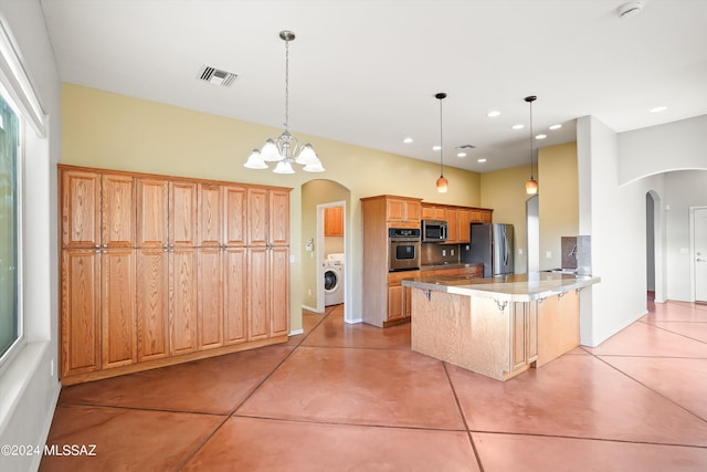 kitchen featuring a breakfast bar, stainless steel appliances, a chandelier, washer / clothes dryer, and hanging light fixtures