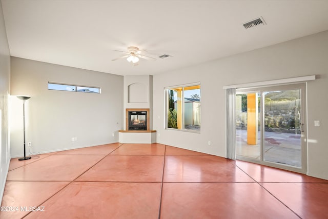 unfurnished living room featuring tile patterned floors and ceiling fan