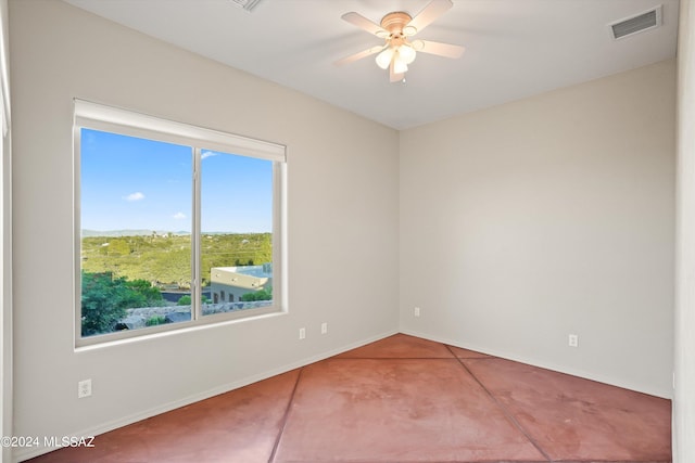 tiled spare room with plenty of natural light and ceiling fan