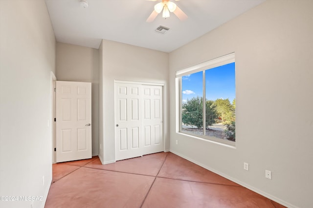 unfurnished bedroom with ceiling fan, a closet, and light tile patterned floors