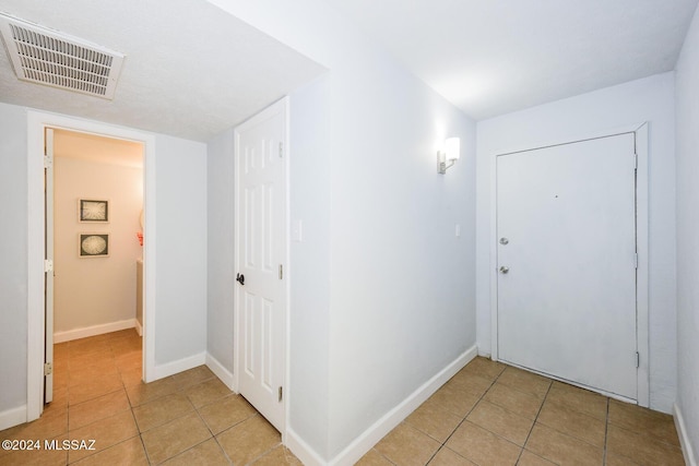 entryway featuring light tile patterned floors, visible vents, and baseboards