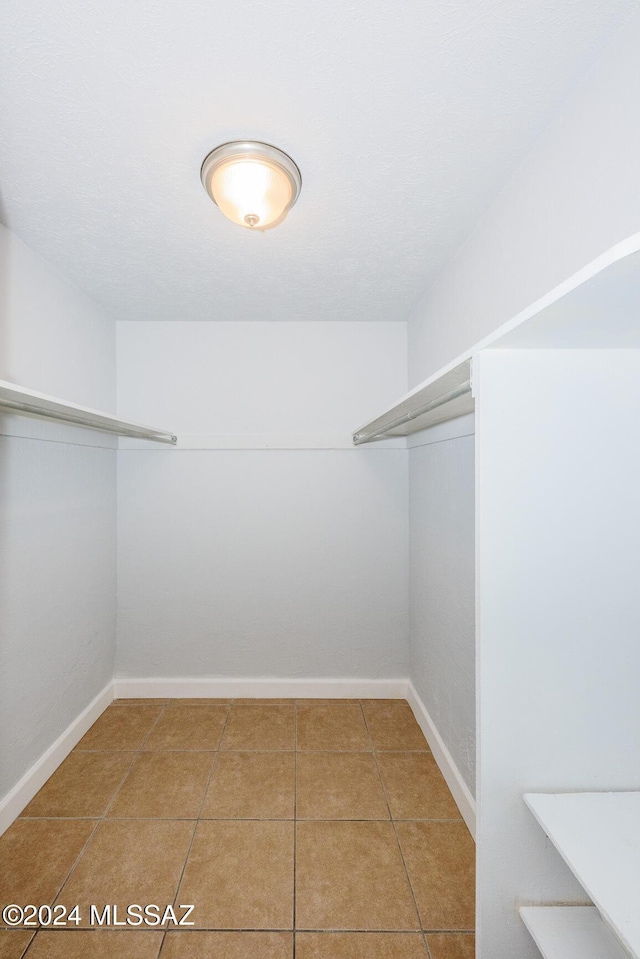 walk in closet with tile patterned flooring