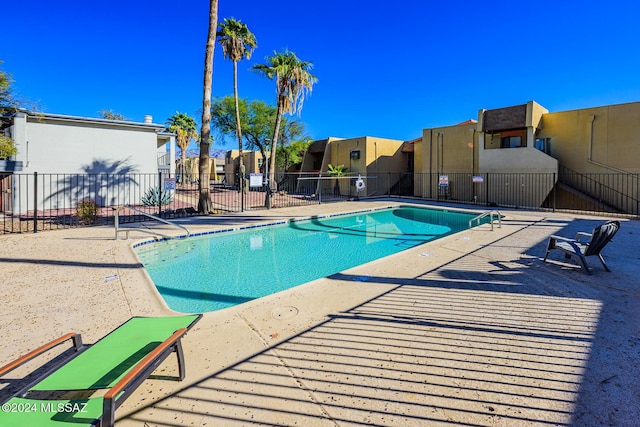 pool featuring a residential view, a patio area, and fence