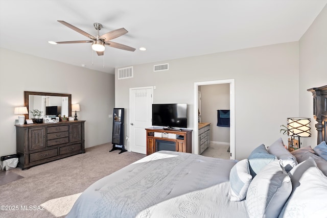 bedroom with ceiling fan, connected bathroom, and light carpet