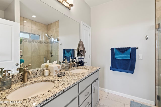 bathroom featuring a shower with door and vanity