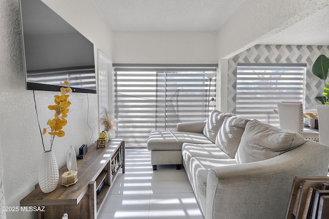 living room featuring a wealth of natural light, a textured ceiling, and a textured wall