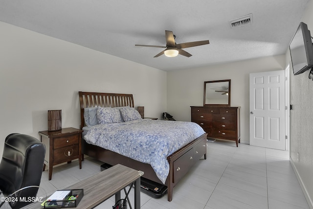 bedroom featuring light tile patterned floors, visible vents, and a ceiling fan