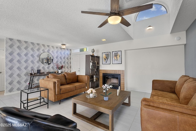 living room featuring an accent wall, a brick fireplace, baseboards, and a textured ceiling