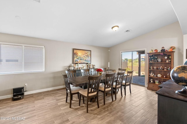 dining area featuring light hardwood / wood-style floors and vaulted ceiling