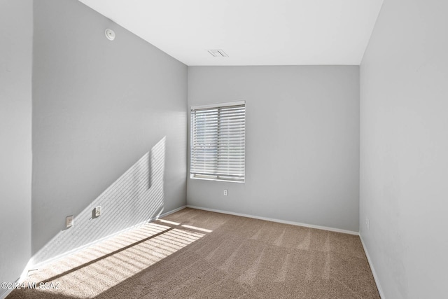 carpeted spare room with vaulted ceiling