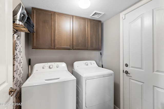 washroom featuring washer and clothes dryer and cabinets