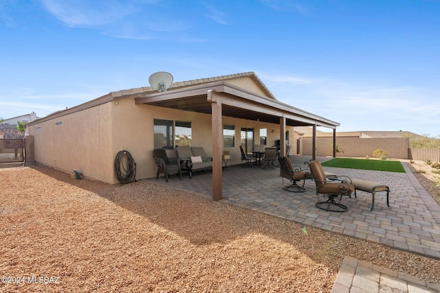 rear view of house with an outdoor hangout area and a patio