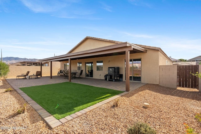 back of property with a mountain view and a patio