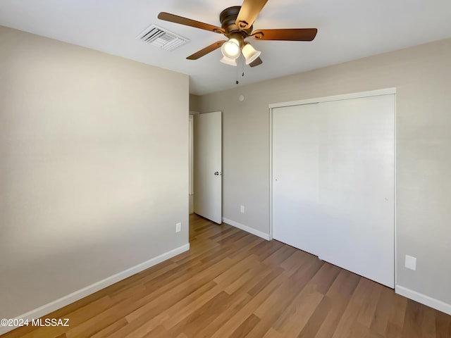 unfurnished bedroom with light wood-type flooring, a closet, and ceiling fan